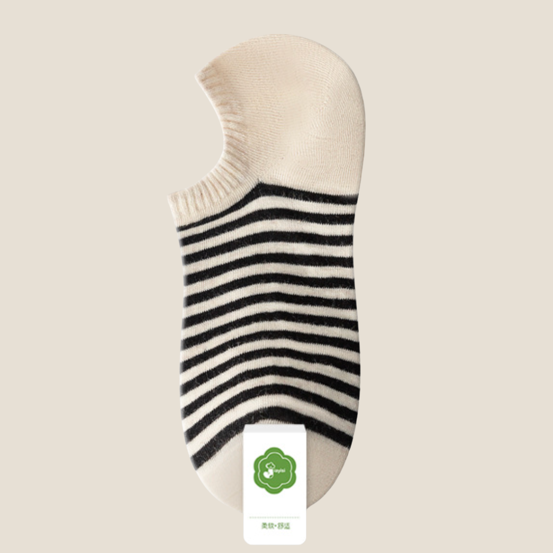 Striped ankle socks in cream with black stripes, featuring a retro striped design. Displayed flat on a light surface.