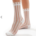 Striped sheer socks in white with vertical sheer stripes, worn on the legs, front view.
