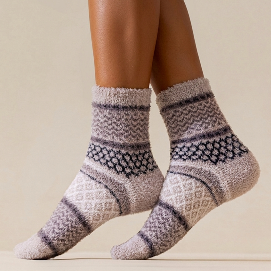 Super warm socks in grey and lavender knit, featuring a Nordic Fair Isle band. Worn on legs for extra warmth.