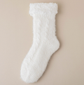 Thermal slipper socks in white, featuring a soft fleece pile. Shown as a single flat-lay on a neutral backdrop.