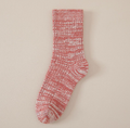 Thick boot socks in red marled knit, featuring a chunky ribbed texture. Worn to pair with winter boots.