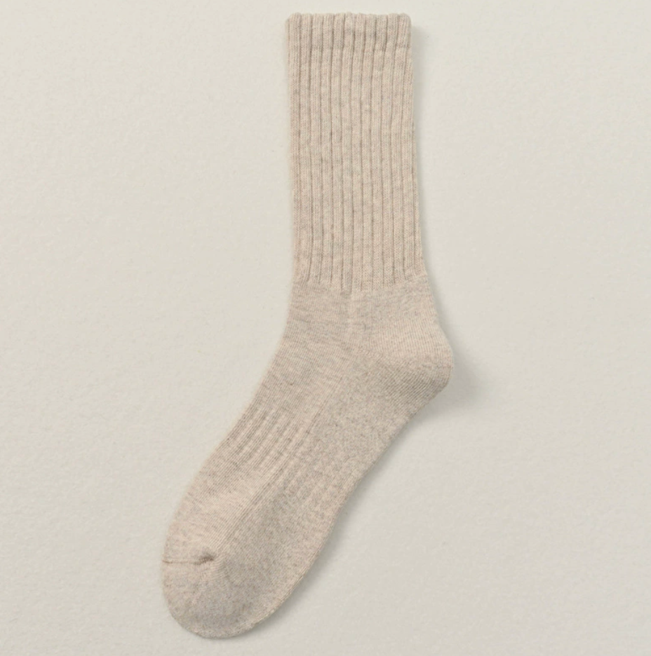 Thick socks business casual in oatmeal beige, featuring a soft ribbed knit. Laid flat on a light backdrop.