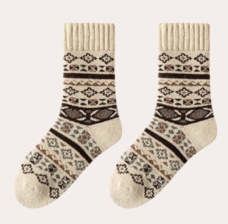 Thick socks for women in ivory wool blend, featuring a geometric Fair Isle motif. Displayed as a flat-lay pair.