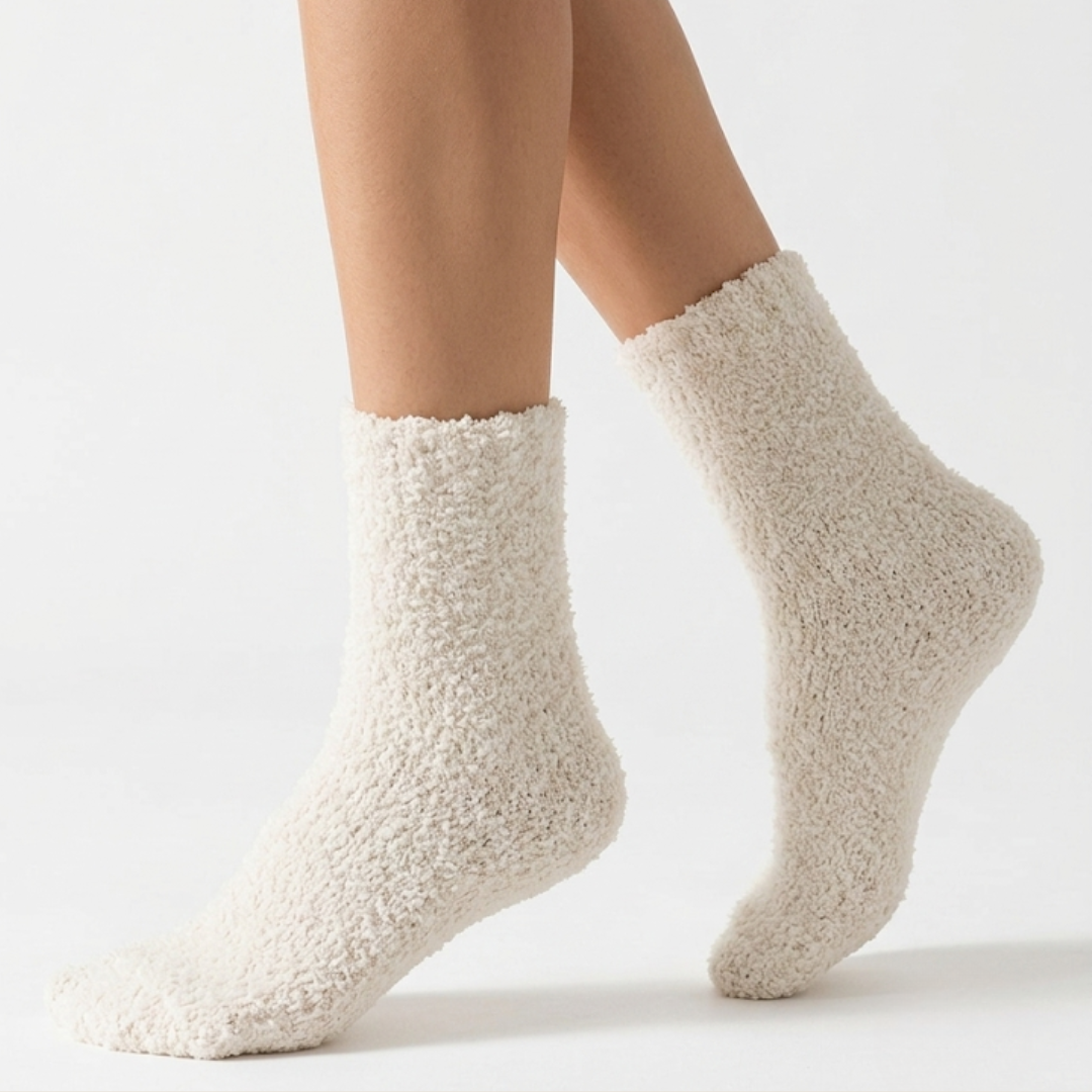 Thick warm socks in cream plush knit, featuring an ultra-soft fuzzy surface. Worn on feet for cozy comfort.