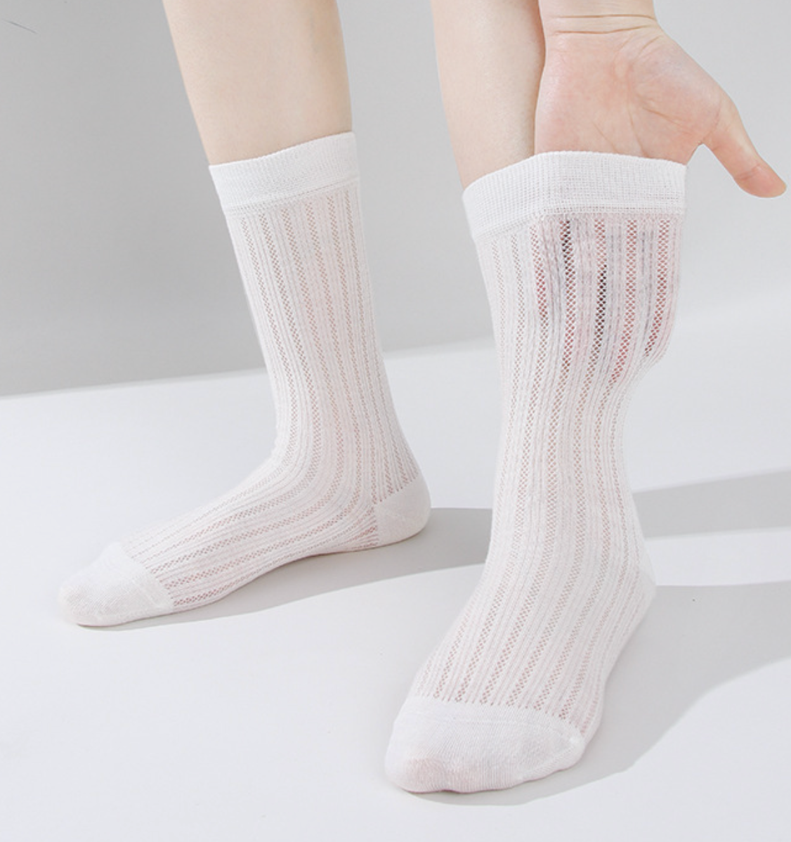 Thin wool dress socks in cream fine-ribbed wool, featuring a lightweight knit. Worn on the feet against a neutral backdrop.