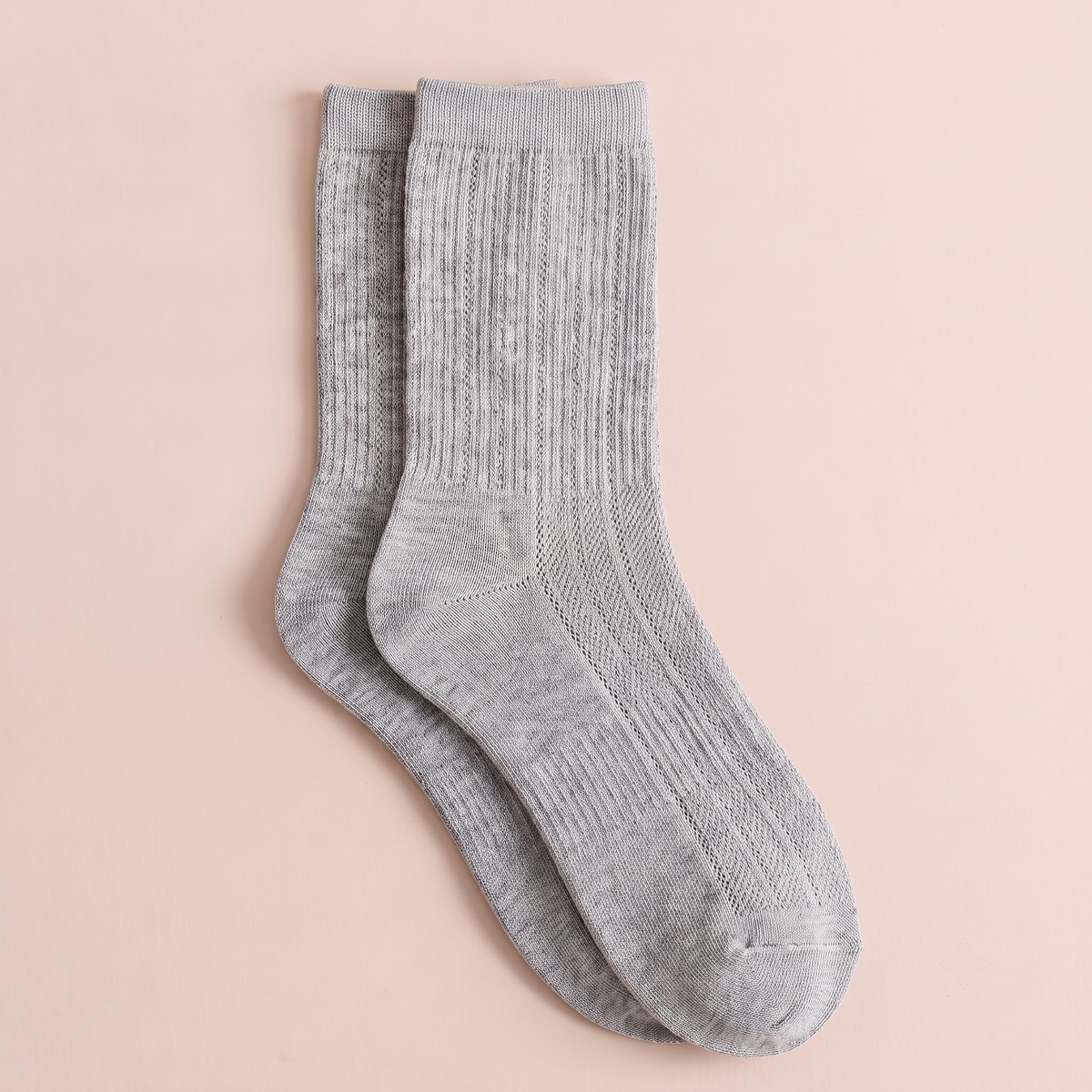 Thin wool dress socks in light grey fine-ribbed wool, featuring a breathable leg. Shown as an upright flat-lay pair.