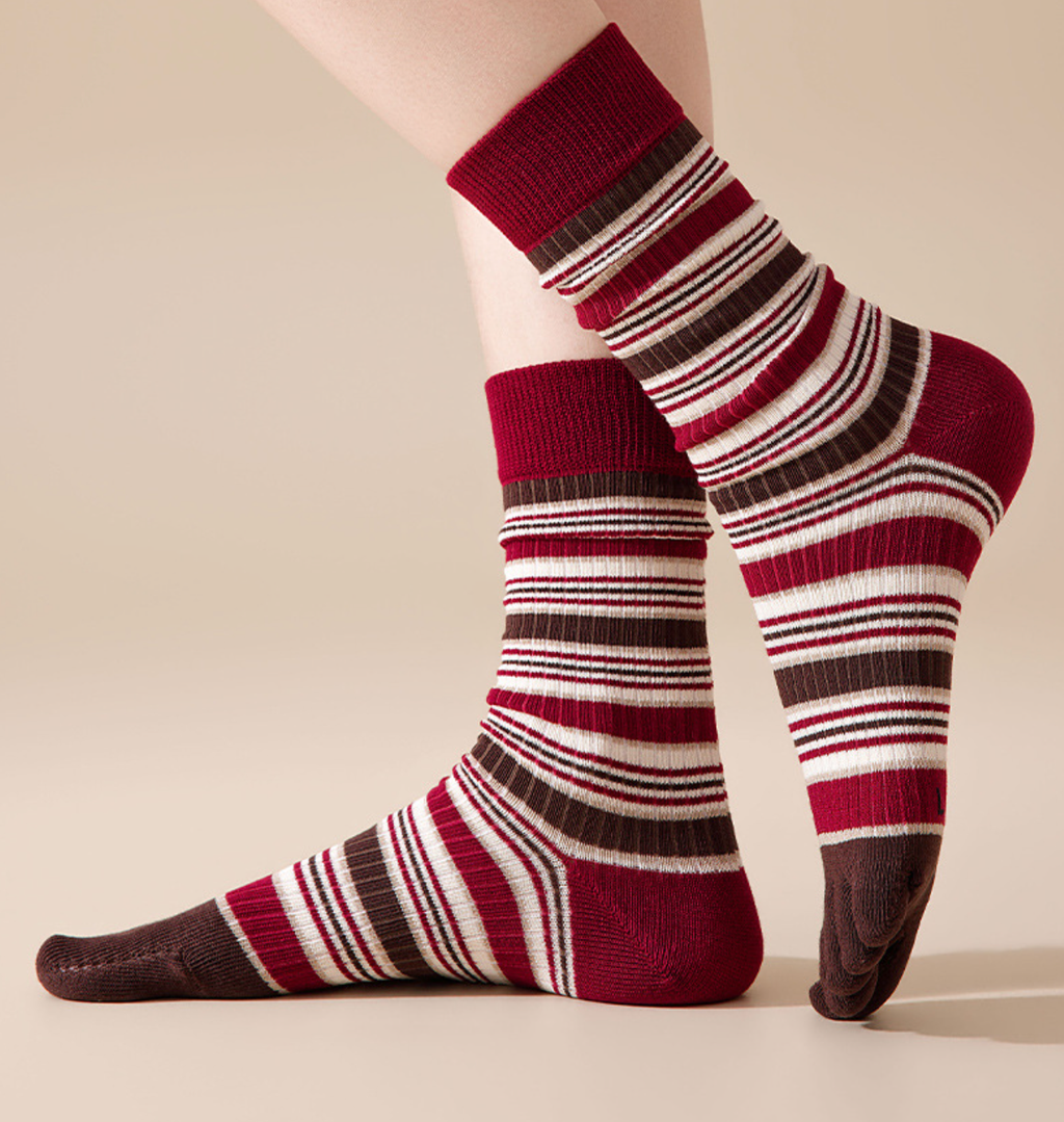 Toe socks for ladies in burgundy and cream stripes, featuring individual toe pockets. Worn on the feet in a seated pose.