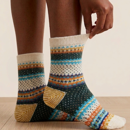 Vintage socks in ivory with a multicolor Nordic stripe pattern, worn on the feet, side view.