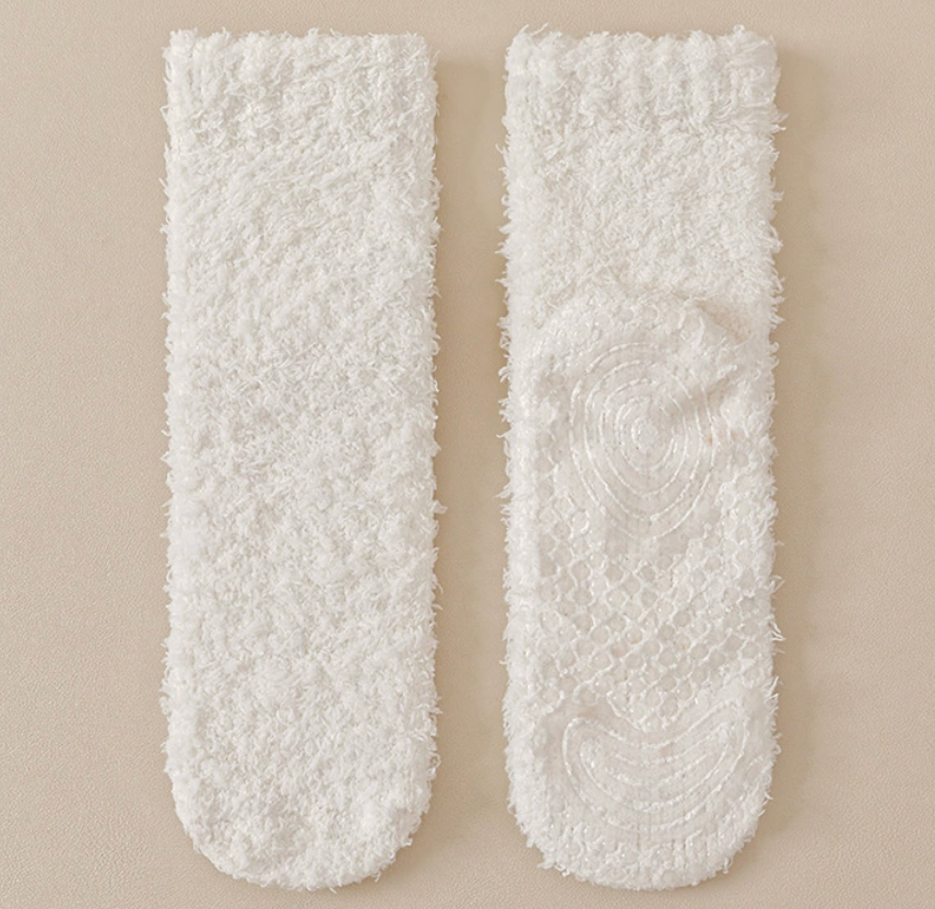 Warm socks for chilblains in ivory plush, featuring a non-slip gripped sole. Shown as a flat-lay pair for gentle circulation warmth.