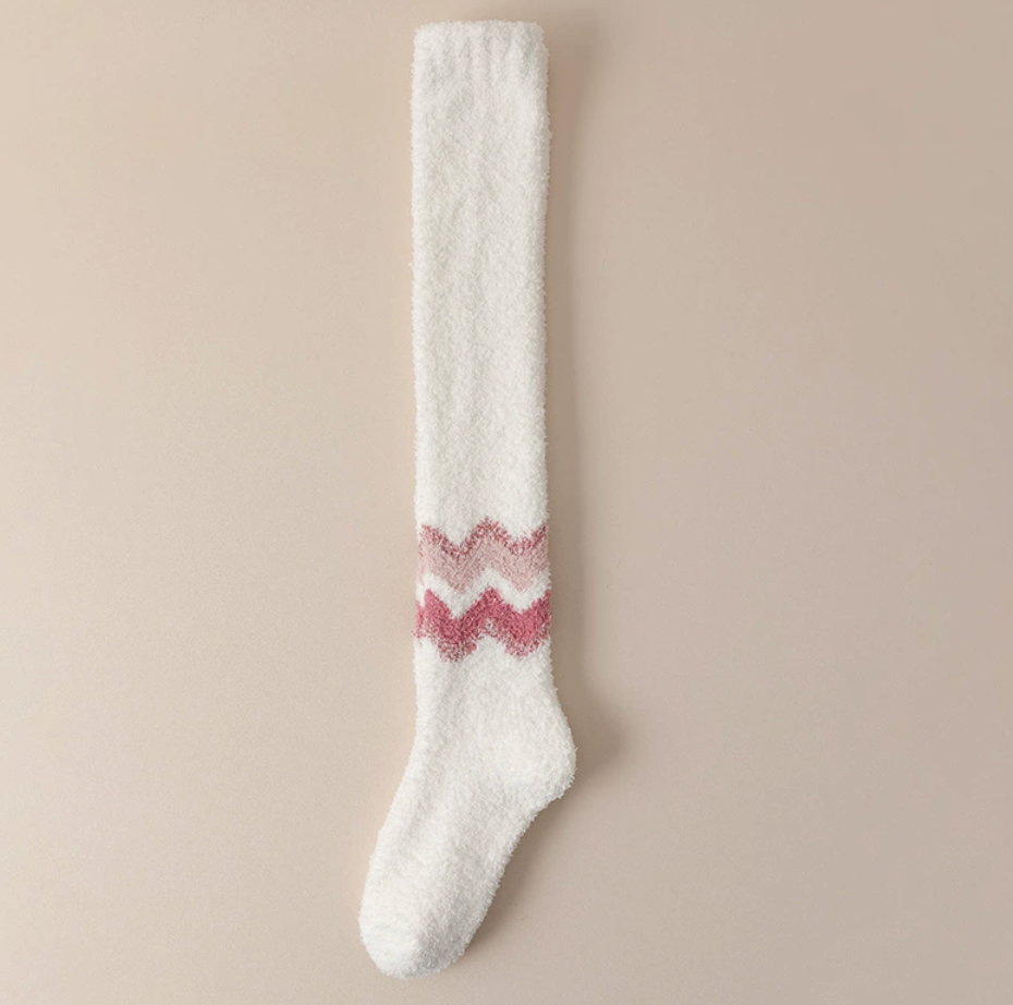 Warm socks for cold feet in cream fuzzy knit, featuring a pink chevron detail. Displayed flat to highlight the plush texture.