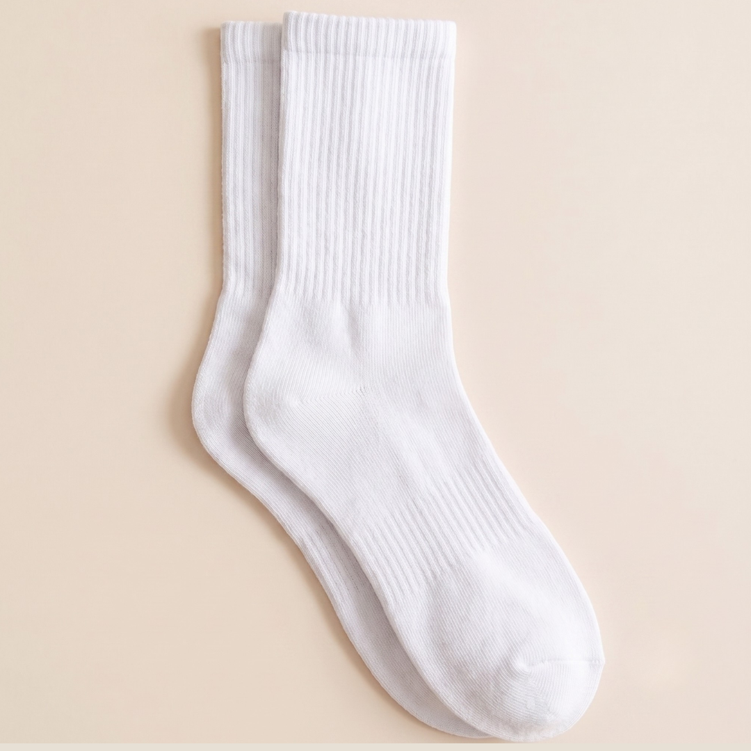 White crew socks in ribbed cotton, featuring a classic crew cuff. Shown as a flat-lay pair on a neutral backdrop.