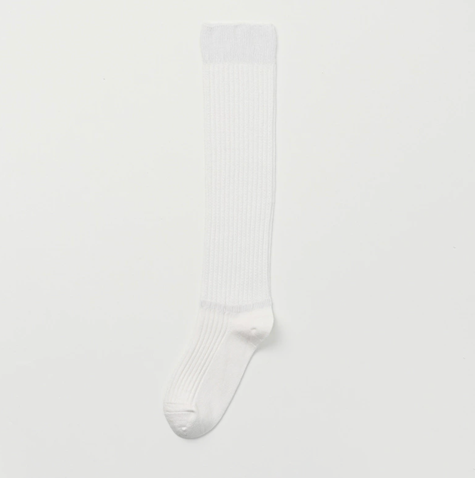 White knee socks in crisp white ribbed cotton, featuring a soft cuff. Shown as a single flat-lay on a light backdrop.