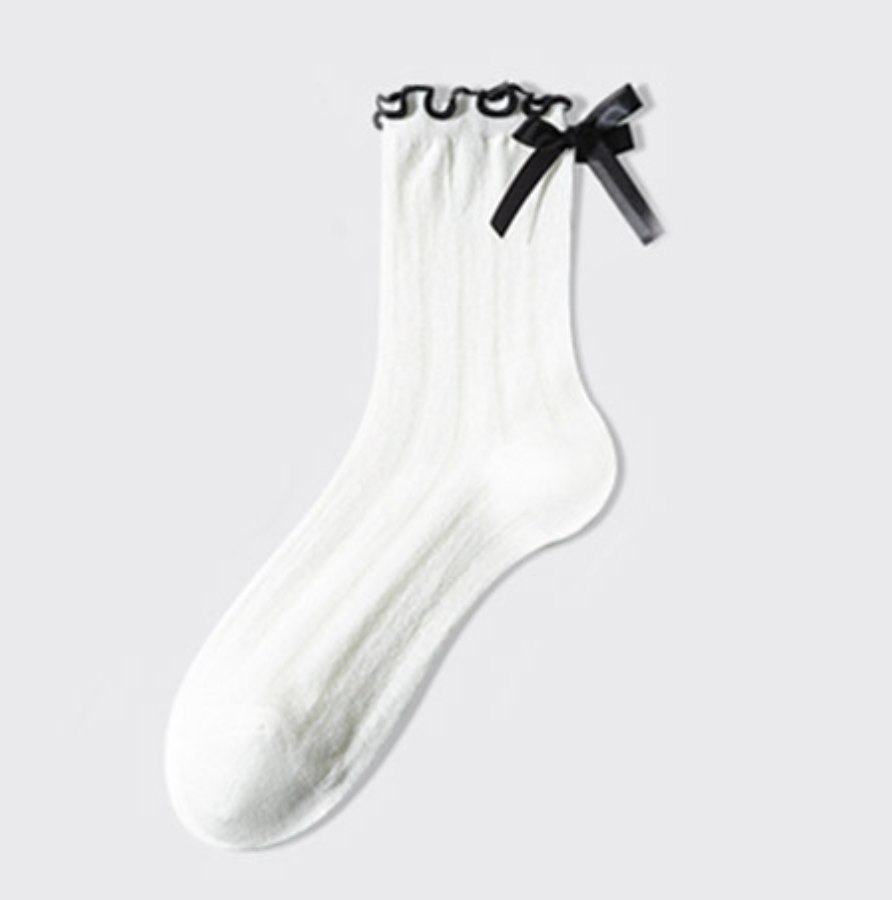 White ruffle socks with a black-edged ruffle and bow, single sock shown flat.