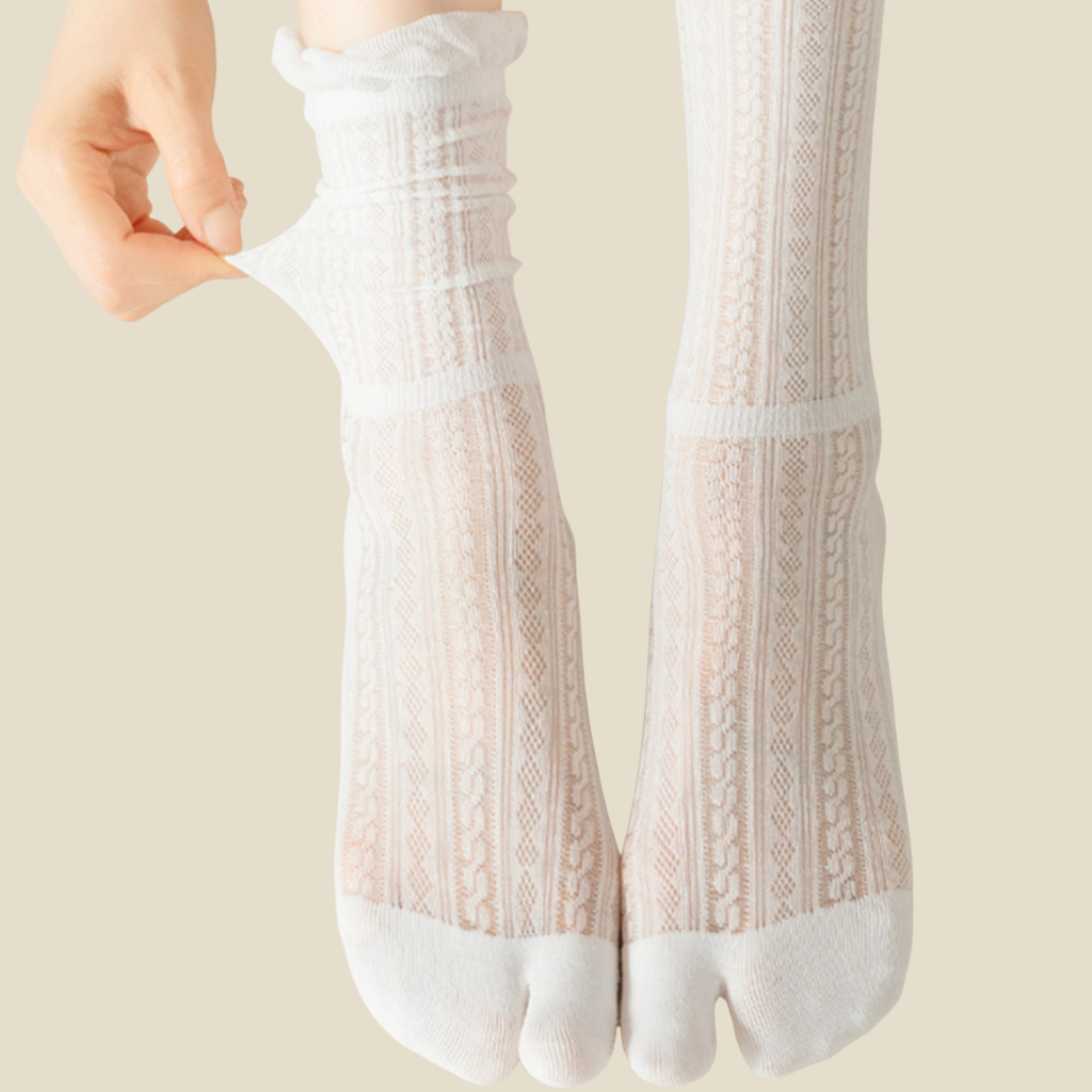 White tabi socks in white, featuring a split-toe ribbed knit. Worn on feet to display the divided toe.