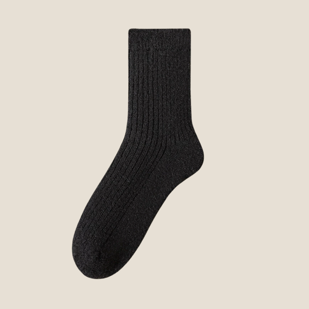 Winter socks for men in black ribbed wool, featuring a dense cushioned knit. Shown standing upright against a neutral backdrop.