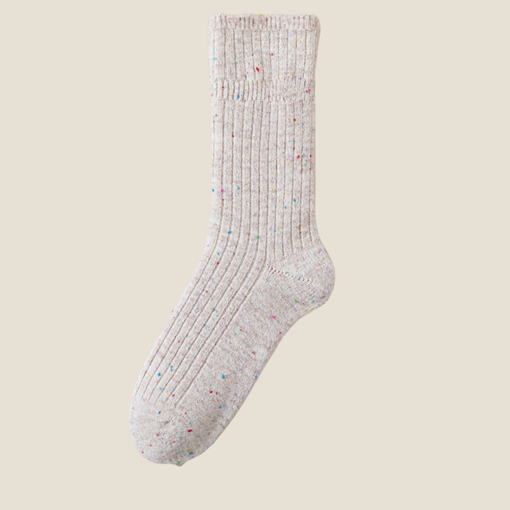 Winter socks for women in oatmeal grey, featuring a flecked ribbed knit. Shown standing upright on a neutral surface.