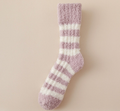 Women's bed socks in mauve and cream fleece, featuring soft horizontal stripes. Shown as a single flat-lay on a warm surface.