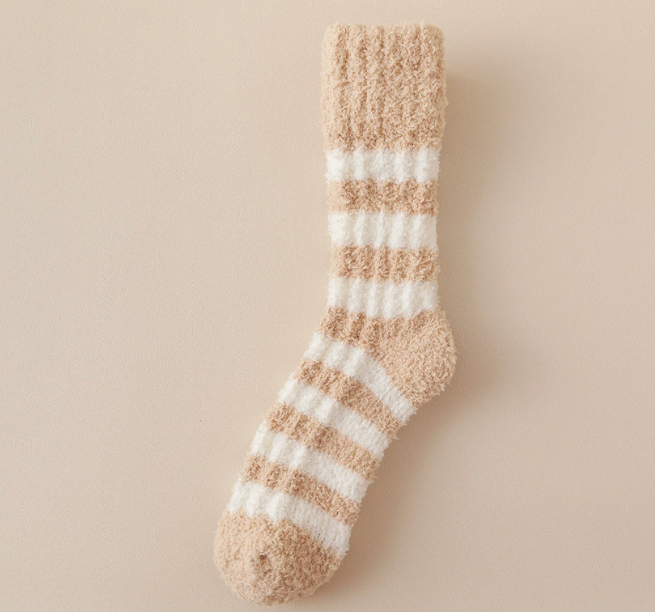 Women's bed socks in tan and ivory plush, featuring gentle striped detailing. Laid flat against a light backdrop.