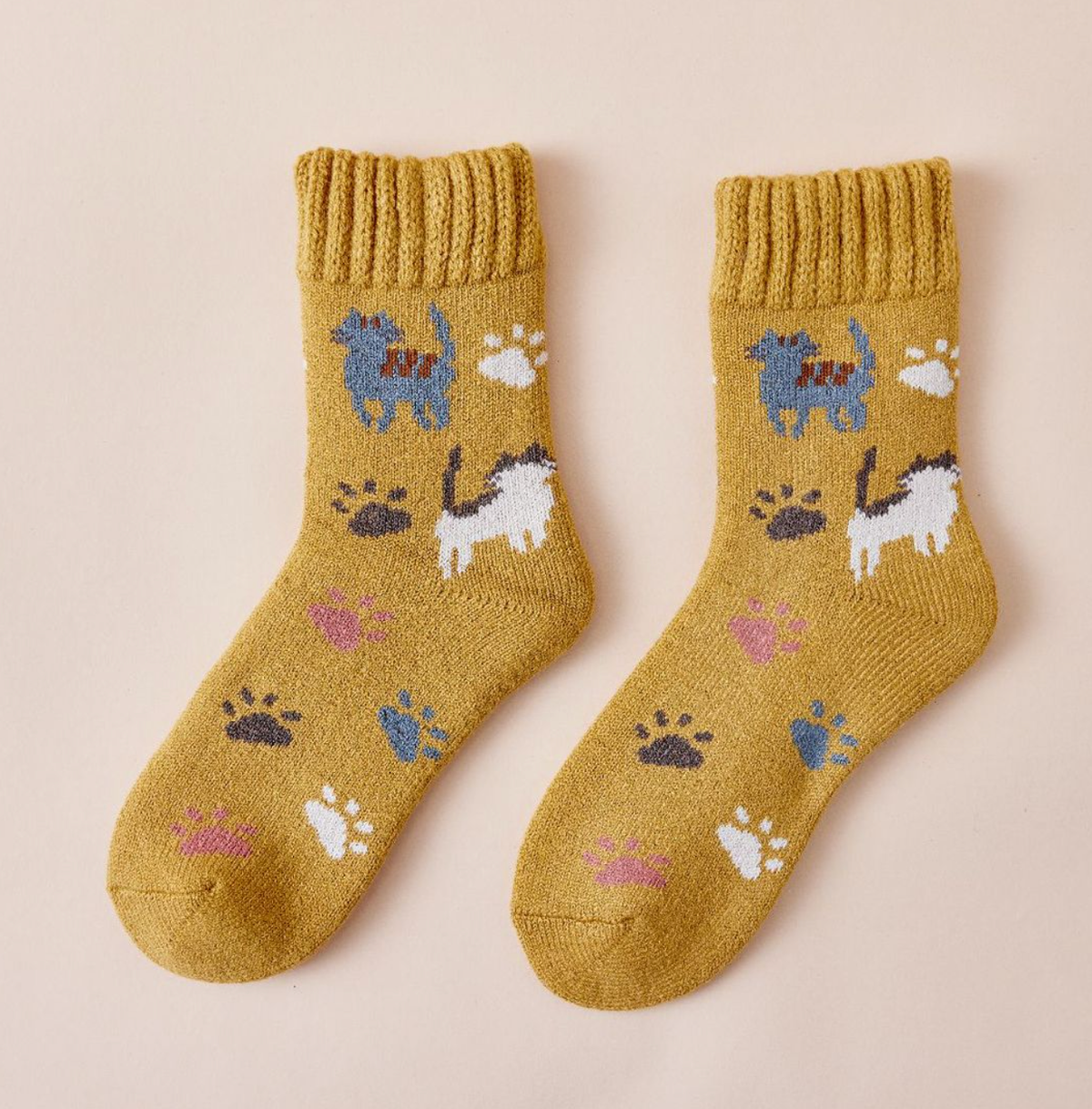 Women's thermal socks in mustard yellow with cats and paw prints, flat-lay pair.