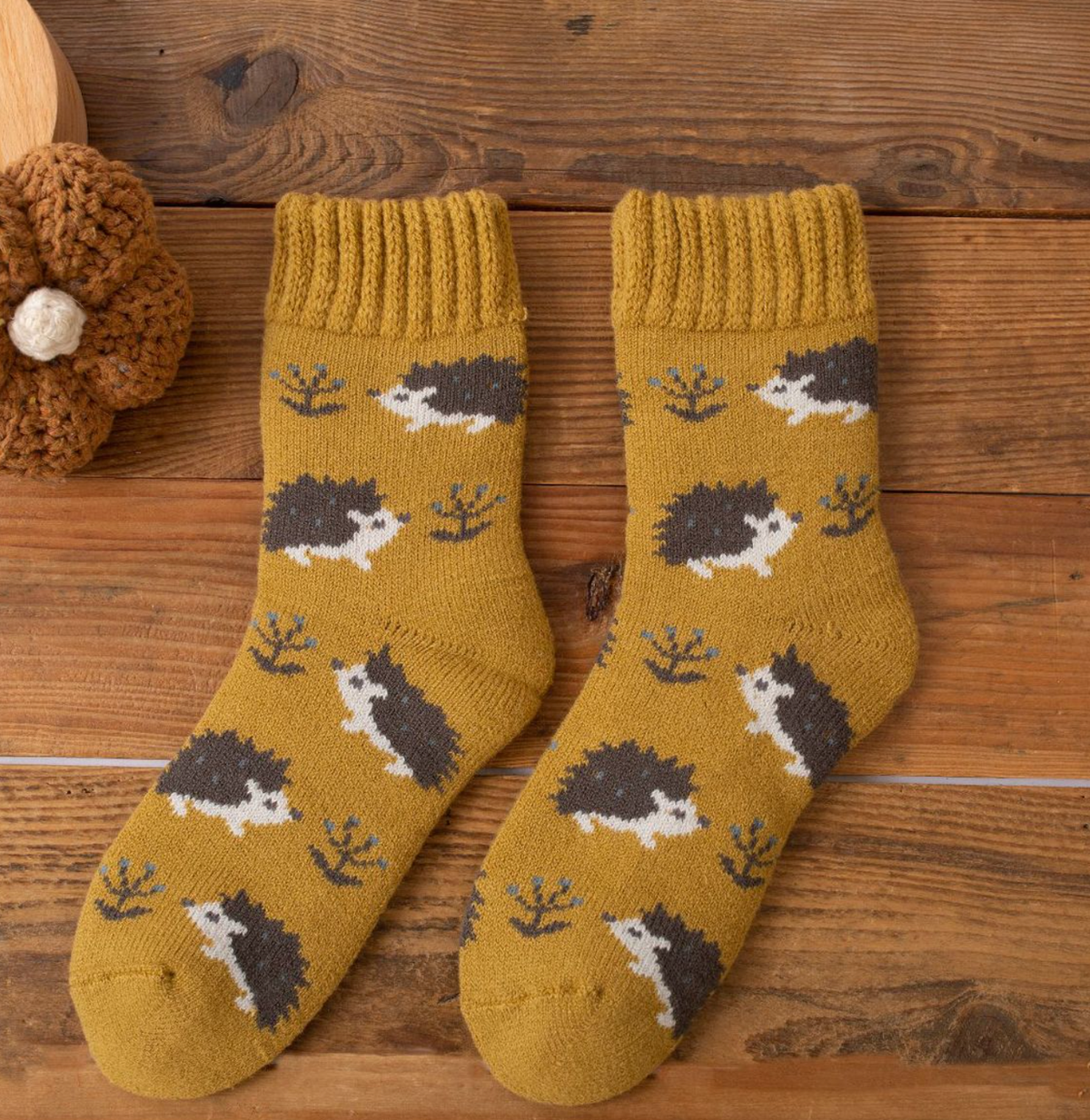 Women's thermal socks in mustard yellow with a hedgehog print, flat-lay pair.
