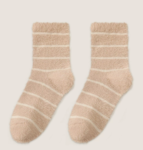 Women's sleep socks in tan and ivory fleece, featuring soft horizontal stripes. Displayed as a flat-lay pair on a light surface.