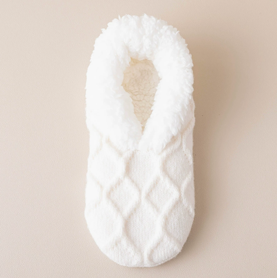 Women's slipper socks in cream diamond knit, featuring a soft sherpa cuff. Displayed flat on a light surface.