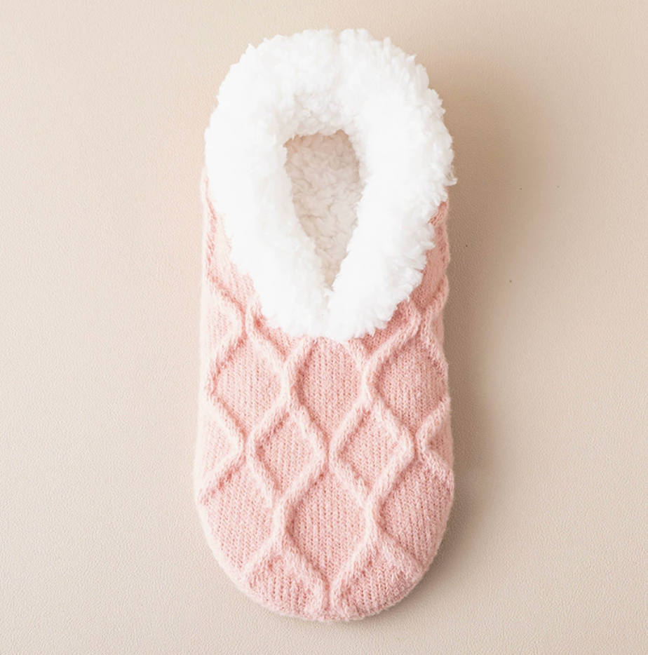 Women's slipper socks in pink diamond knit, featuring a fleece-lined cuff. Shown as a single flat-lay on a neutral backdrop.