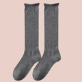 Women's thin wool dress socks in grey fine-ribbed wool, featuring a sleek profile. Shown as an upright flat-lay pair.