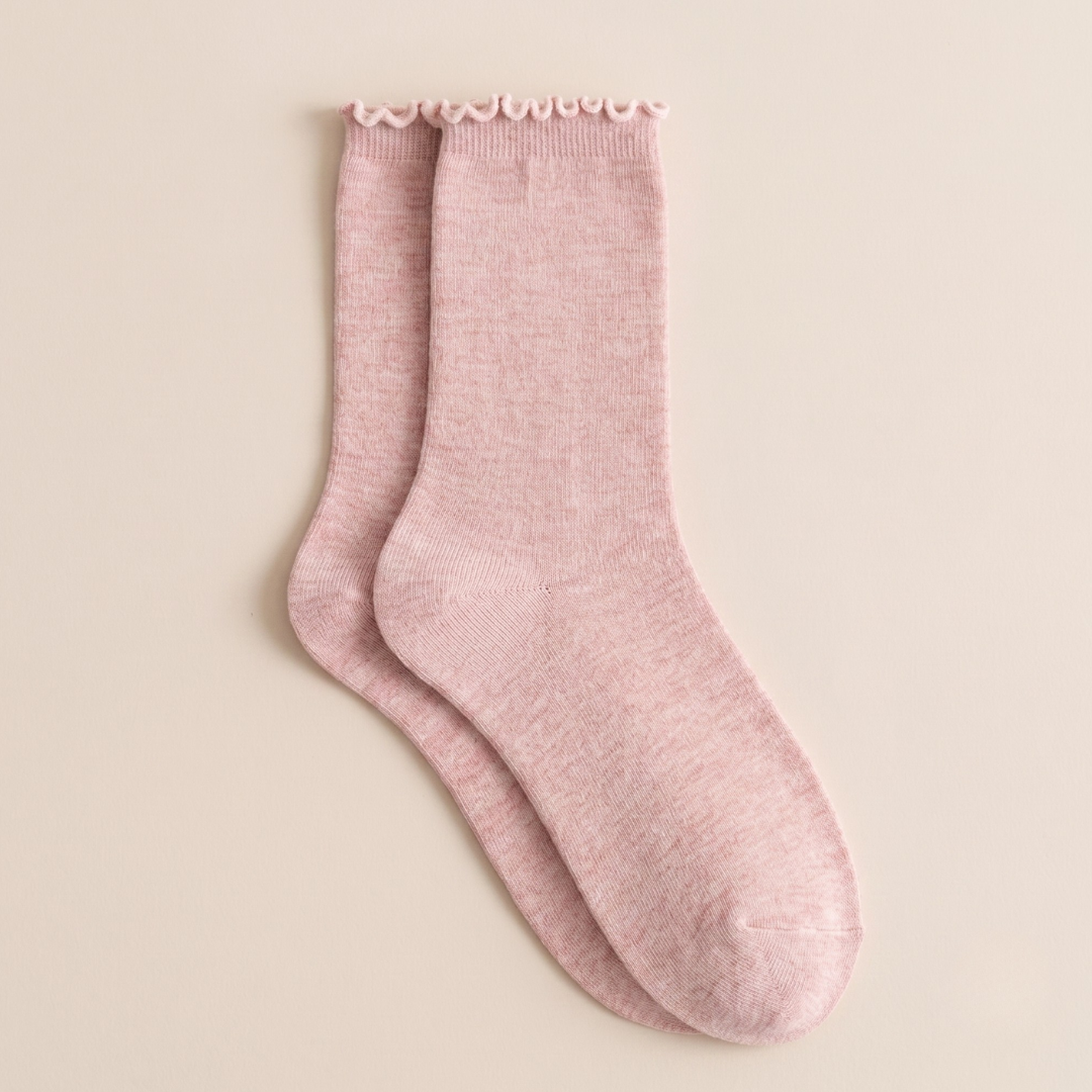 Women's wool boot socks in dusty pink, featuring a ribbed body and scalloped cuff. Shown as a single flat-lay on a neutral backdrop.