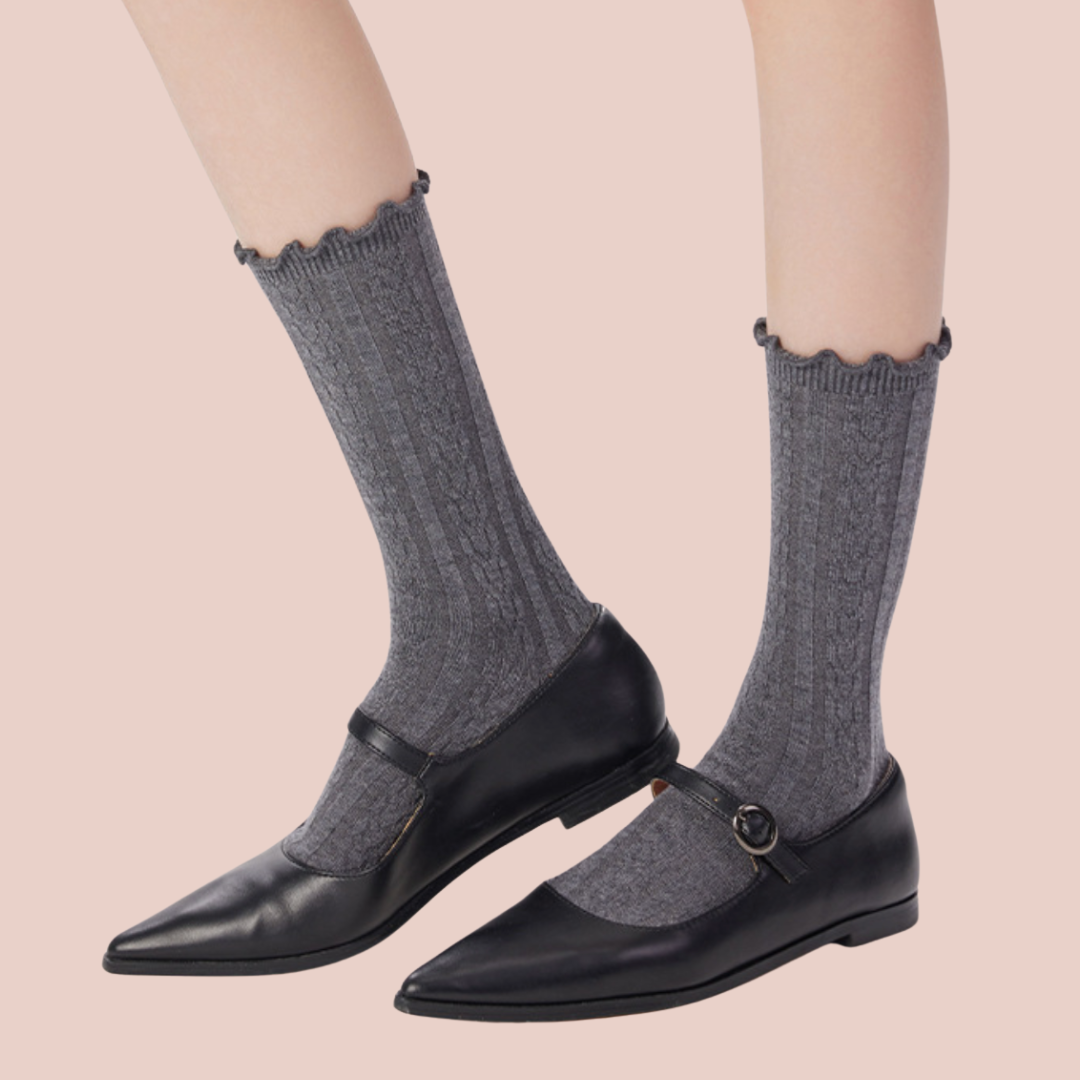 Women's wool dress socks in grey ribbed wool, featuring a fine texture. Worn with black loafers.