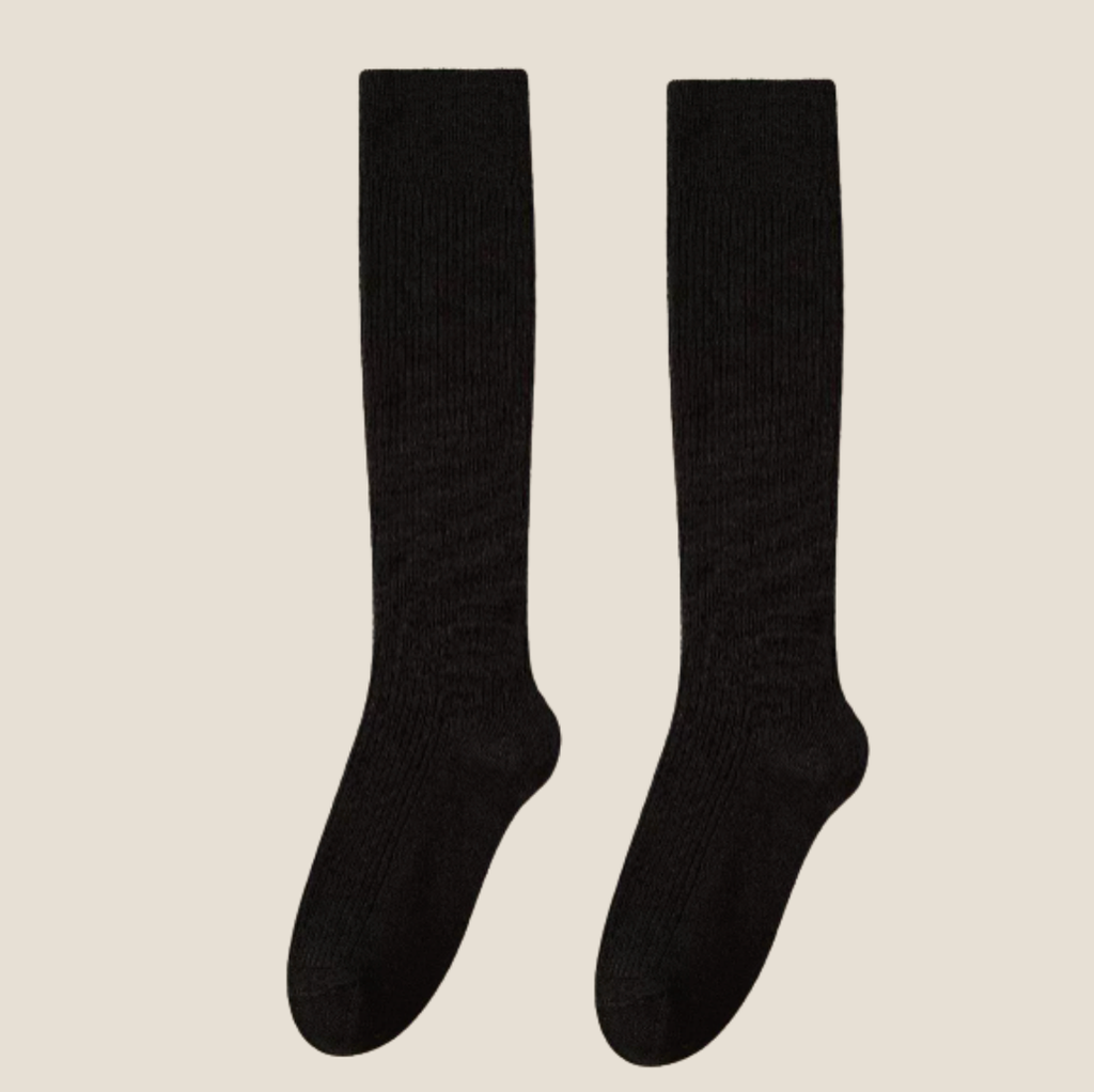Women's wool knee socks in black ribbed wool, featuring a stretchy cuff. Shown as an upright flat-lay pair on a neutral surface.
