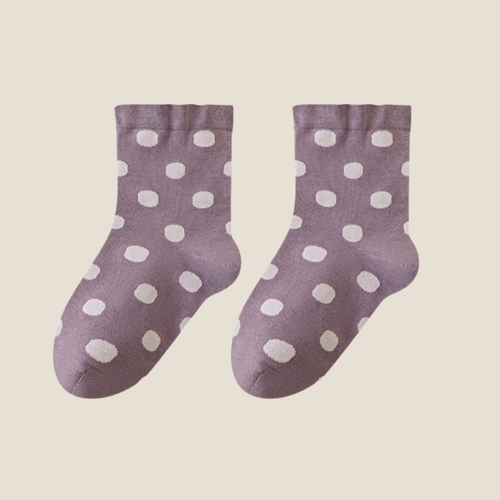 Wool bed socks in dusty purple wool blend, featuring white polka dots. Displayed as a flat-lay pair on a soft surface.