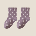 Wool bed socks in dusty purple wool blend, featuring white polka dots. Displayed as a flat-lay pair on a soft surface.