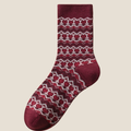 Wool Christmas socks in burgundy Fair Isle pattern, a single sock shown flat to display the snowflake motif.