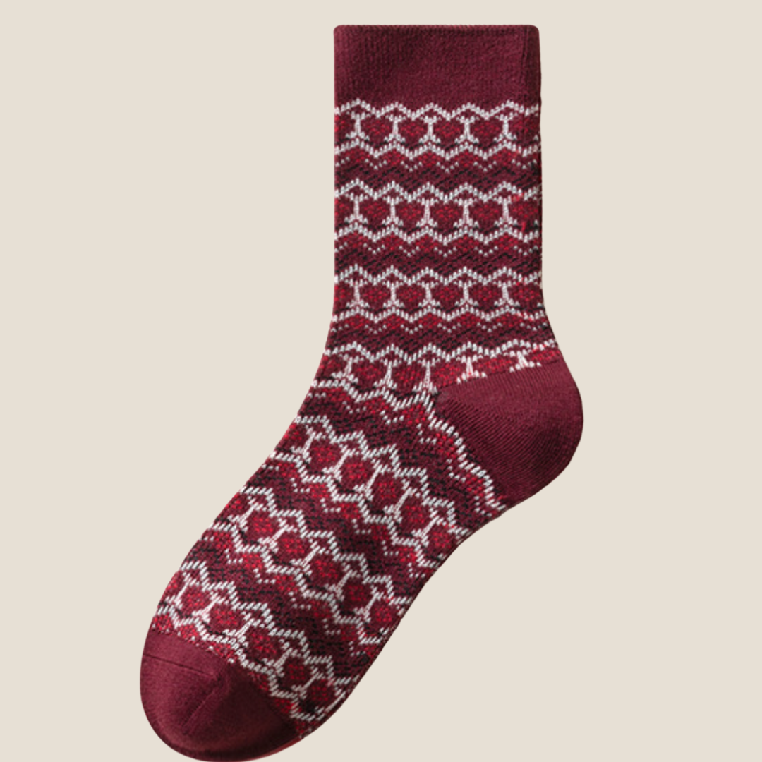 Wool Christmas socks in burgundy Fair Isle pattern, a single sock shown flat to display the snowflake motif.